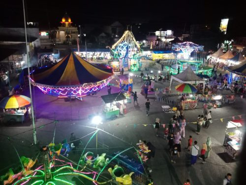 Pasar malam. Wahana Bianglala seperti roda kehidupan berputar di malam hari. Kadang di atas, kadang di bawah. Ketika di puncak karier, maka ada saatnya berada di tengah, bahkan di bawah.