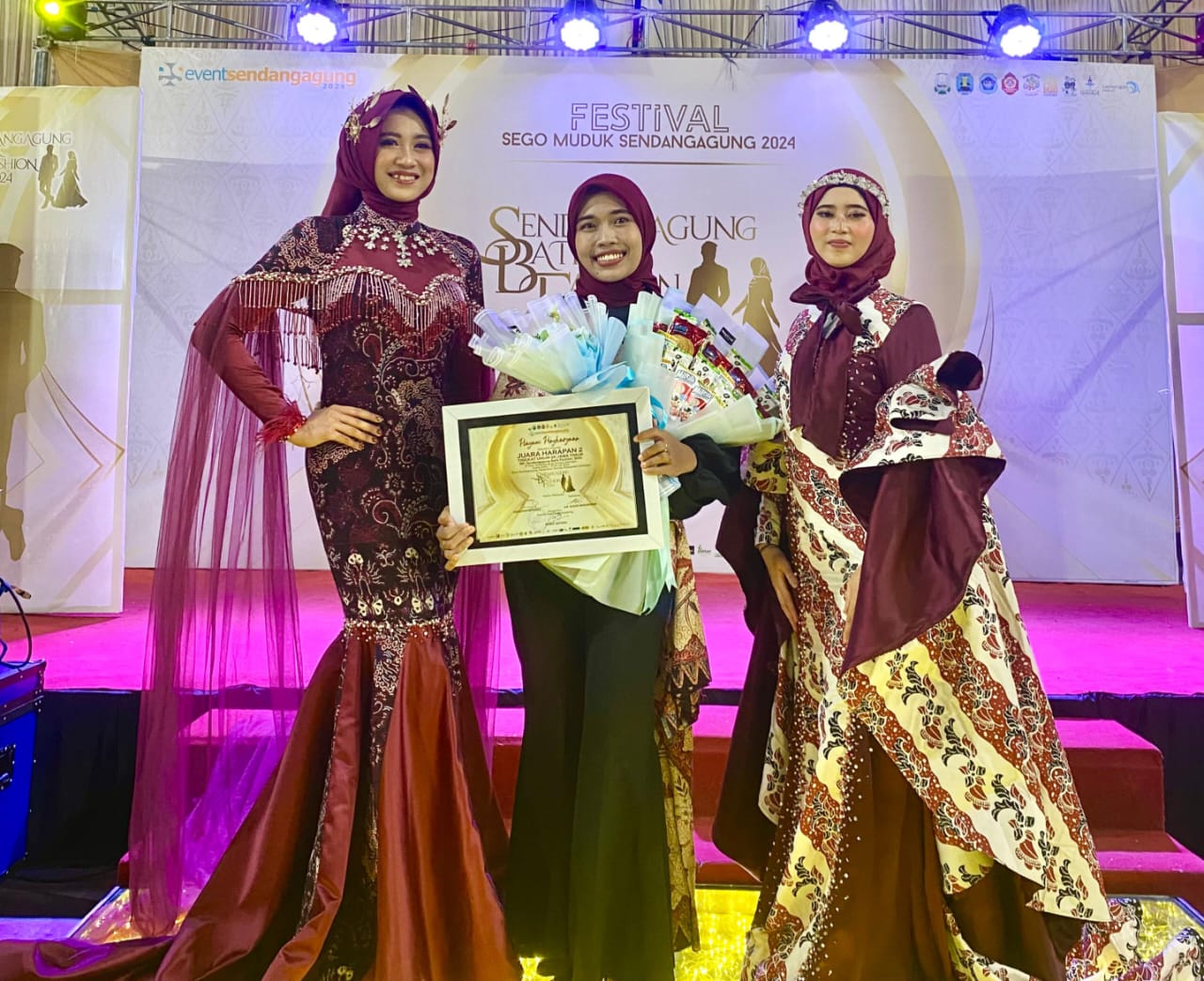 Najwa Fauzus Sa’aadah tak pernah menyangka, even lomba pertamanya dalam Sendangagung Batik Fashion 2024 berbuah manis. Gaun rancangan ibu satu anak alumnus Ponpes Al Ishlah itu berhasil menyabet juara. Tagar.co – Sendangagung Batik Fashion (SBF) yang digelar Pemdes Sendangagung, Paciran, Lamongan, itu masih menyisakan kesan mendalam bagi Najwa Fauzus Sa’aadah. Dua gaun hasil rancangan alumnus Ponpes Al Ishlah tahun 2014 tersebut berhasil meraih juara. Ibu satu anak asli Sendangagung itu tak menyangka, SBF yang dihadiri Camat Paciran H. Sami’an MM, anggota DPRD Lamongan, dan juga Bupati Dr H Yuhronur Efendi, itu menjadi even pertamanya yang berbuah manis. Gaun-gaun hasil rancangan Faza—panggilan Najwa Fauzus Sa’aadah—berhasil menjadi juara II dan harapan II pada ajang yang berlangsung di Watungkal Edupark Sendangagung (WES) Kamis-Sabtu (18-20/7/2024). Para penonton yang hadir tidak hanya dari Sendangagung, juga dari tetangga desa  seperti Kecamatan Paciran dan Solokuro. Lomba Fashion SBF tingkat SMA berlangsung pada Jumat (19/7/24) malam. Untuk kategori umum sekaligus launching motif batik baru berlangsung pada Sabtu (20/7/24). Partisipan acara tersebut beragam, mulai dari Lamongan, Bojonegoro, hingga Surabaya. Bagi Faza, even SBF menjadi pengalaman lomba pertamanya mendesain baju. Dia bersyukur dapat meraih dua gelar, yakni juara kedua dan harapan II. Baginya, hal tersebut menjadi kebanggaan tersendiri. “Karena saingannya berasal dari berbagai daerah,” tutur lulusan D3 Tata Busana Universitas Negeri Surabaya (Unesa) tersebut. Baca juga: Pembantu Warung Soto Itu Bisa Kuliahkan Anaknya di UGM Utusan Desa Pada lomba Fashion Show tingkat SMA, gaun rancangan Faza dibawakan Yuk Lamongan Stephaney Dewantari berhasil meraih juara II se-Kabupaten Lamongan. Busana pertama yang dibuatnya itu atas nama utusan desa untuk mengikuti acara launching motif batik baru Sendangagung. Ada tiga motif yang  di-launching seperti motif batik Rahayuning, Rontal, hingga Sego Langgi. “Busana yang saya buat ini menggunakan kain batik motif Rontal,” ungkapnya. Menurut filosofinya, Rontal diambil dari bahasa jawa  “ron” yang berati daun, dan “tal” dari kata ental atau siwalan, sesuai dengan kegunaan daun ental yang multifungsi. “Harapannya, batik tidak hanya difungsikan sebagai sarung atau jarik (kain dengan motif aneka batik), tapi bisa dimodifikasi menjadi gamis, mukena, aksesoris, gaun pengantin, serta aneka macam kerajinan tangan dan lain lain,” paparnya. Pada dasarnya daun siwalan berbentuk seperti kipas. “Selain daun siwalan, juga mengusung ikon Lamongan lainnya seperti ikan bandeng dan lele dengan inovasi terbaru,” jelas putri pasangan Sukaryudi (almarhum) dan Linsiana tersebut. Gaun rancangan Faza ditampilkan dengan siluet mermaid dengan dominasi kain batik, duches, dan tulle bridal. Busana juga dihiasi rangkaian payet secara menyeluruh. Pada bagain dada dihiasi payet rantai secara menjalar sampai belakang sebagai center of interest. “Sehingga busana yang saya buat ini tampak kelihatan mewah dan elegan,” jelasnya. Menurut desain batiknya, Rontal memberi pesan tersirat agar generasi muda dapat menjaga alam, budaya, dan melestarikan batik. “Untuk durasi pengerjaan membuat busana ini membutuhkan waktu sekitar 6 hari,” paparnya. Bermanfaat bagi Sesama Faza kemudian menceritakan gaun rancangannya kedua, yang dikenakan model Hamidatul Istiqomah Mustahad. Busana tersebut menggunakan kain motif Batik Khas Lamongan (BKL)—motif ini biasa digunakan untuk jarit pada busana wanita. “Tapi untuk kali ini saya bikin dalam bentuk gaun,” ujarnya. Durasi pengerjaan busana yang sangat singkat, yakni hanya dalam waktu tiga hari sebelum hari H, sehingga membuatnya harus memutar otak. “Saya berpikir, bagaimana caranya agar busana ini pengerjaanya tidak menghabiskan waktu yang lama, tapi nanti hasilnya tetap menarik,” terangnya. Dia kemudian menemukan inspirasi desain yang sesuai, tapi membutuhkan bahan yang tidak sedikit. Busana tersebut dibuat menggunakan siluet mermaid yang didominasi kain batik dan kain maxmara silk. Pada bagian badan depan busana dihiasi sedikit rangkaian payet agar menambah nilai glamour. Sedangkan pada lengannya dibuat dalam desain ruffle sebagai center of interest. “Sehingga desain busana yang saya buat tampak simpel, tapi tetap terlihat menarik dan glamour,” kata ibu dari Shezan Syazwina Eleanor tersebut. Faza yang kesehariannya berprofesi sebagai penjahit ini  merasa bersyukur diterima di Jurusan Tata Busana Unesa Surabaya, karena pasca lulus kuliah langsung bisa mengamalkan ilmu dan bisa cari uang sendiri. Menjadi penjahit bisa menciptakan lapangan kerja, walau sekarang baru punya dua asisten,” jelas istri Afkarul Azka yang juga asli Sendangagung itu. Faza juga berharap dapat memberi kontribusi positif terhadap kemajuan desa Sendangagung, yang menurutnya tiap hari semakin bersinar. “Tidak hanya di tingkat  Kabupaten Lamongan tapi juga tingkat provinsi,” kata perempuan dengan prinsip sebaik-baik manusia adalah yang paling bermanfaat untuk sesama tersebut. (#) Jurnalis Sri Asian Penyunting Darul Setiawan.