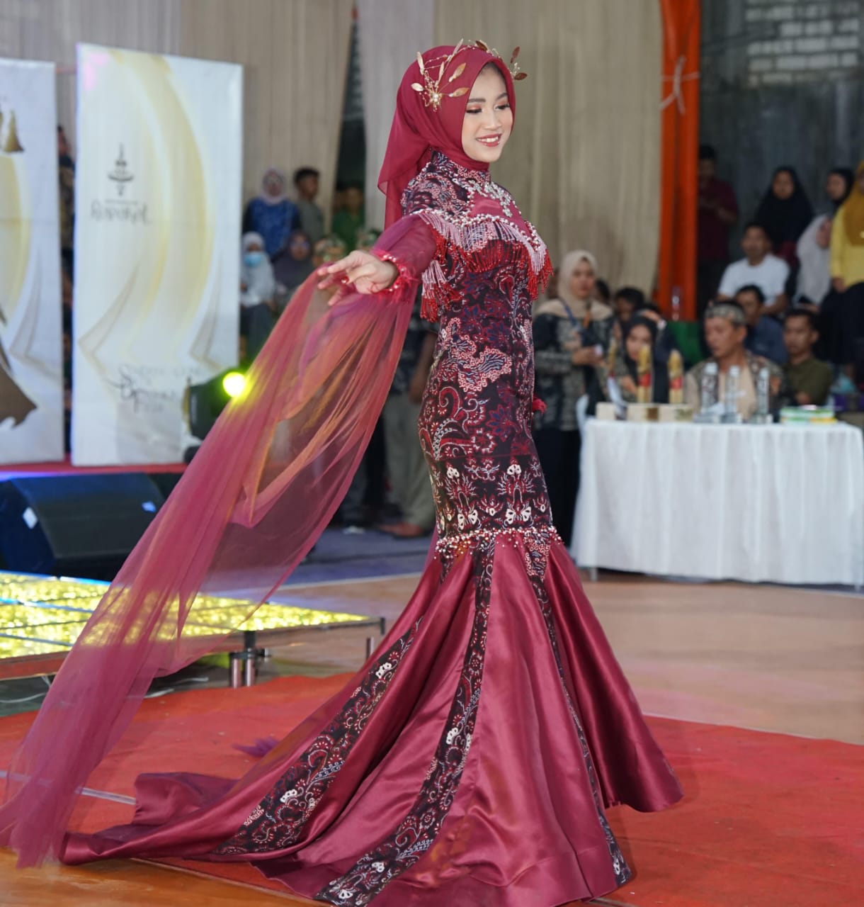 Najwa Fauzus Sa’aadah tak pernah menyangka, even lomba pertamanya dalam Sendangagung Batik Fashion 2024 berbuah manis. Gaun rancangan ibu satu anak alumnus Ponpes Al-Ishlah itu berhasil menyabet juara.

Tagar.co – Sendangagung Batik Fashion (SBF) yang digelar Pemdes Sendangagung, Paciran, Lamongan, itu masih menyisakan kesan mendalam bagi Najwa Fauzus Sa’aadah. Dua gaun hasil rancangan alumnus Ponpes Al-Ishlah tahun 2014 tersebut berhasil meraih juara.

Ibu satu anak asli Sendangagung itu tak menyangka, SBF yang dihadiri Camat Paciran H. Sami’an MM, anggota DPRD Lamongan, dan juga Bupati Dr H Yuhronur Efendi, itu menjadi even pertamanya yang berbuah manis.

Gaun-gaun hasil rancangan Faza—panggilan Najwa Fauzus Sa’aadah—berhasil menjadi juara II dan harapan II pada ajang yang berlangsung di Watungkal Edupark Sendangagung (WES) Kamis-Sabtu (18-20/7/2024).

Para penonton yang hadir tidak hanya dari Sendangagung, juga dari tetangga desa  seperti Kecamatan Paciran dan Solokuro. Lomba Fashion SBF tingkat SMA berlangsung pada Jumat (19/7/24) malam. Untuk kategori umum sekaligus launching motif batik baru berlangsung pada Sabtu (20/7/24). Partisipan acara tersebut beragam, mulai dari Lamongan, Bojonegoro, hingga Surabaya.

Bagi Faza, even SBF menjadi pengalaman lomba pertamanya mendesain baju. Dia bersyukur dapat meraih dua gelar, yakni juara kedua dan harapan II. Baginya, hal tersebut menjadi kebanggaan tersendiri. “Karena saingannya berasal dari berbagai daerah,” tutur lulusan D3 Tata Busana Universitas Negeri Surabaya (Unesa) tersebut.

Baca juga: Pembantu Warung Soto Itu Bisa Kuliahkan Anaknya di UGM

Gaun dengan batik motif Batik Khas Lamongan (BKL) karya Najwa Fauzus Sa’aadah di  Sendangagung Batik Fashion  2024. (Tagar.co/Sri Asian)

Utusan Desa

Pada lomba Fashion Show tingkat SMA, gaun rancangan Faza dibawakan Yuk Lamongan Stephaney Dewantari berhasil meraih juara II se-Kabupaten Lamongan. Busana pertama yang dibuatnya itu atas nama utusan desa untuk mengikuti acara launching motif batik baru Sendangagung.

Ada tiga motif yang  di-launching seperti motif batik Rahayuning, Rontal, hingga Sego Langgi. “Busana yang saya buat ini menggunakan kain batik motif Rontal,” ungkapnya.

Menurut filosofinya, Rontal diambil dari bahasa jawa  “ron” yang berati daun, dan “tal” dari kata ental atau siwalan, sesuai dengan kegunaan daun ental yang multifungsi. “Harapannya, batik tidak hanya difungsikan sebagai sarung atau jarik (kain dengan motif aneka batik), tapi bisa dimodifikasi menjadi gamis, mukena, aksesoris, gaun pengantin, serta aneka macam kerajinan tangan dan lain lain,” paparnya.

Pada dasarnya daun siwalan berbentuk seperti kipas. “Selain daun siwalan, juga mengusung ikon Lamongan lainnya seperti ikan bandeng dan lele dengan inovasi terbaru,” jelas putri pasangan Sukaryudi (almarhum) dan Linsiana tersebut.

Gaun rancangan Faza ditampilkan dengan siluet mermaid dengan dominasi kain batik, duches, dan tulle bridal. Busana juga dihiasi rangkaian payet secara menyeluruh. Pada bagain dada dihiasi payet rantai secara menjalar sampai belakang sebagai center of interest. “Sehingga busana yang saya buat ini tampak kelihatan mewah dan elegan,” jelasnya.

Menurut desain batiknya, Rontal memberi pesan tersirat agar generasi muda dapat menjaga alam, budaya, dan melestarikan batik. “Untuk durasi pengerjaan membuat busana ini membutuhkan waktu sekitar 6 hari,” paparnya.

Gaun dari batik motif Rontal rancangan Najwa Fauzus Sa’aadah di  Sendangagung Batik Fashion 2024. (Tagar.co/Sri Asian)

Bermanfaat bagi Sesama

Faza kemudian menceritakan gaun rancangannya kedua, yang dikenakan model Hamidatul Istiqomah Mustahad. Busana tersebut menggunakan kain motif Batik Khas Lamongan (BKL)—motif ini biasa digunakan untuk jarit pada busana wanita. “Tapi untuk kali ini saya bikin dalam bentuk gaun,” ujarnya.

Durasi pengerjaan busana yang sangat singkat, yakni hanya dalam waktu tiga hari sebelum hari H, sehingga membuatnya harus memutar otak. “Saya berpikir, bagaimana caranya agar busana ini pengerjaanya tidak menghabiskan waktu yang lama, tapi nanti hasilnya tetap menarik,” terangnya.

Dia kemudian menemukan inspirasi desain yang sesuai, tapi membutuhkan bahan yang tidak sedikit. Busana tersebut dibuat menggunakan siluet mermaid yang didominasi kain batik dan kain maxmara silk.

Pada bagian badan depan busana dihiasi sedikit rangkaian payet agar menambah nilai glamour. Sedangkan pada lengannya dibuat dalam desain ruffle sebagai center of interest. “Sehingga desain busana yang saya buat tampak simpel, tapi tetap terlihat menarik dan glamour,” kata ibu dari Shezan Syazwina Eleanor tersebut.

Faza yang kesehariannya berprofesi sebagai penjahit ini  merasa bersyukur diterima di Jurusan Tata Busana Unesa Surabaya, karena pasca lulus kuliah langsung bisa mengamalkan ilmu dan bisa cari uang sendiri. Menjadi penjahit bisa menciptakan lapangan kerja, walau sekarang baru punya dua asisten,” jelas istri Afkarul Azka yang juga asli Sendangagung itu.

Faza juga berharap dapat memberi kontribusi positif terhadap kemajuan desa Sendangagung, yang menurutnya tiap hari semakin bersinar. “Tidak hanya di tingkat  Kabupaten Lamongan tapi juga tingkat provinsi,” kata perempuan dengan prinsip sebaik-baik manusia adalah yang paling bermanfaat untuk sesama tersebut. (#)

Jurnalis Sri Asian Penyunting Darul Setiawan.