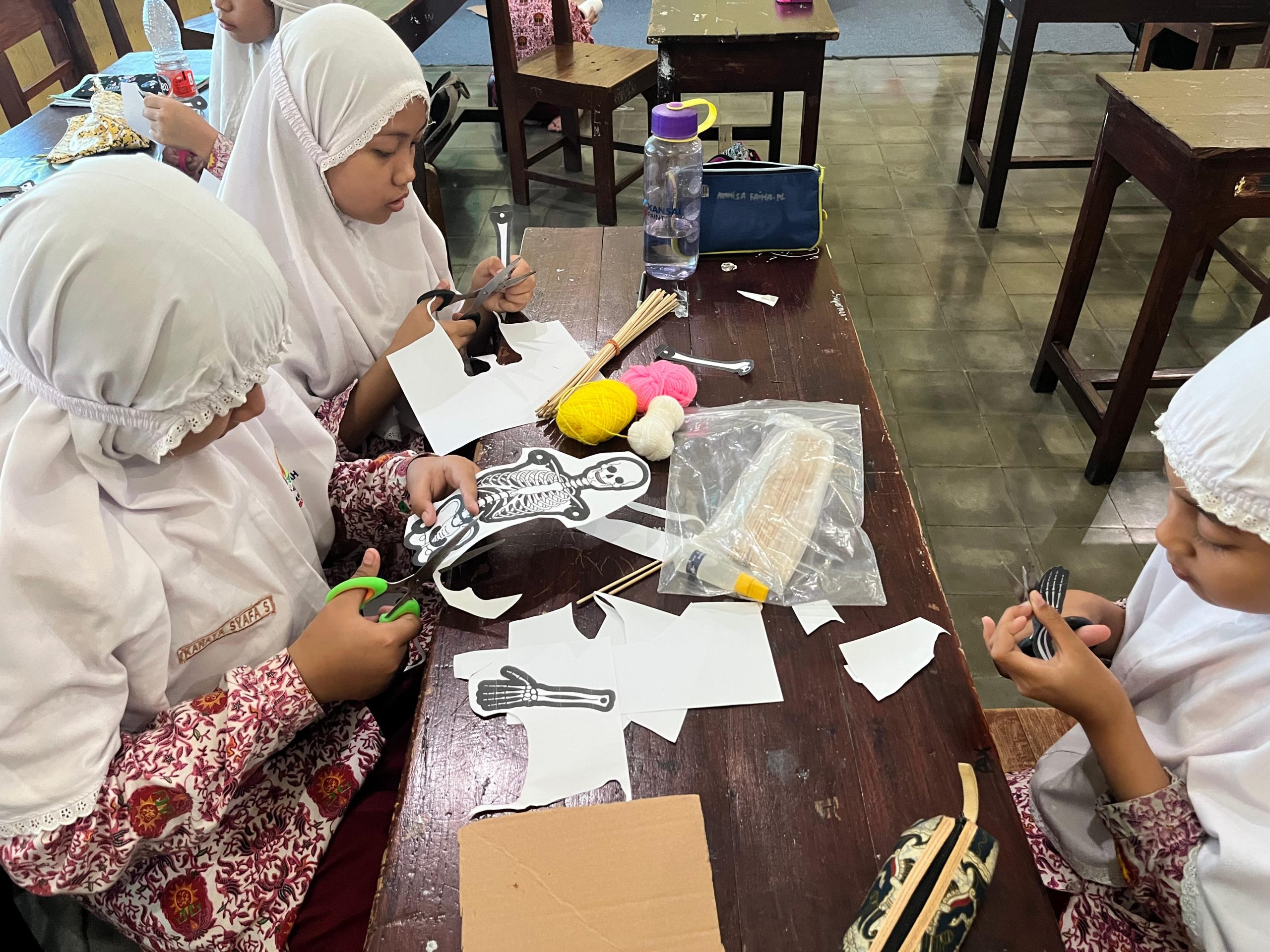 Memahami rangka manusia kini lebih seru. Murid SD Muhammadiyah Kompleks Gresik (SD Mugres) membuat kreasi wayang rangka berbahan kardus bekas, belajar sambil berkreasi.