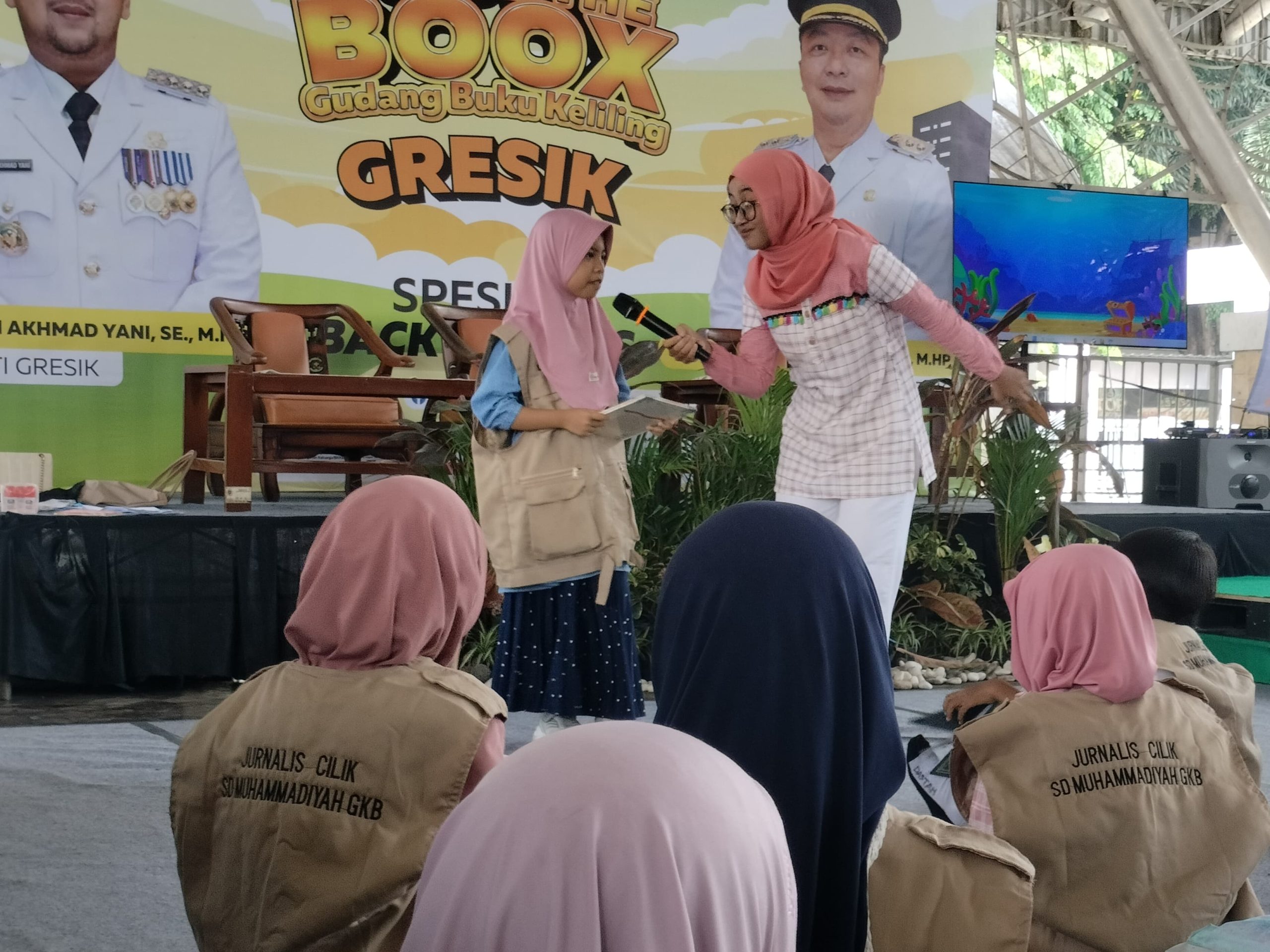 Siswa Mugeb Primary School mengikuti Pekan Ceria Kampung Dongeng di WEP. Mereka belanja buku dan mainan edukatif, belajar berhemat melalui dongeng interaktif, juga ikut pelatihan membuat buku laporan keuangan sederhana.