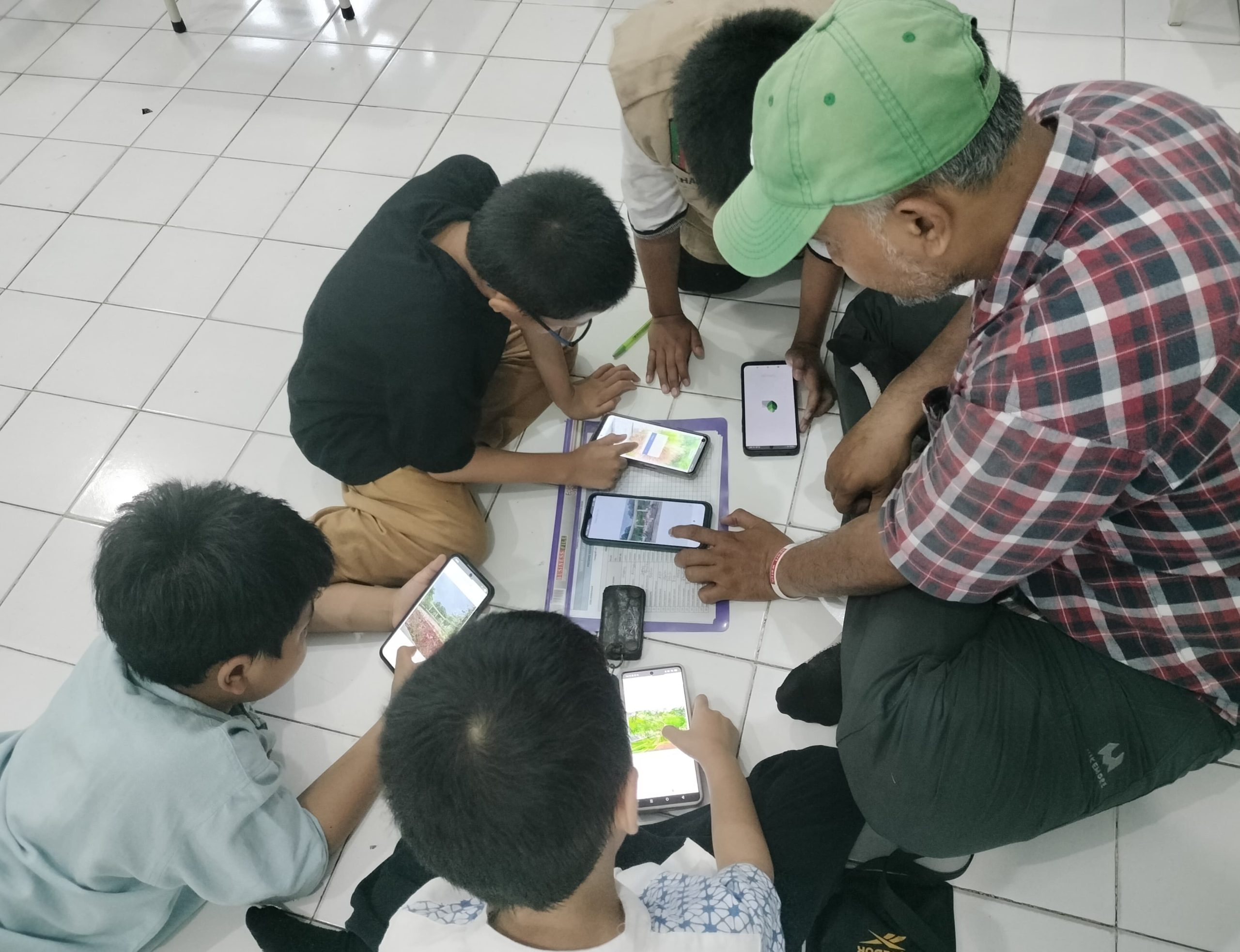 Siswa SD Muhammadiyah 1 GKB Gresik perdana kelas luar ruang. Belajar fokus, komposisi, hingga teknik fotografi levitasi dan frog eyes di Taman Bundaran GKB.