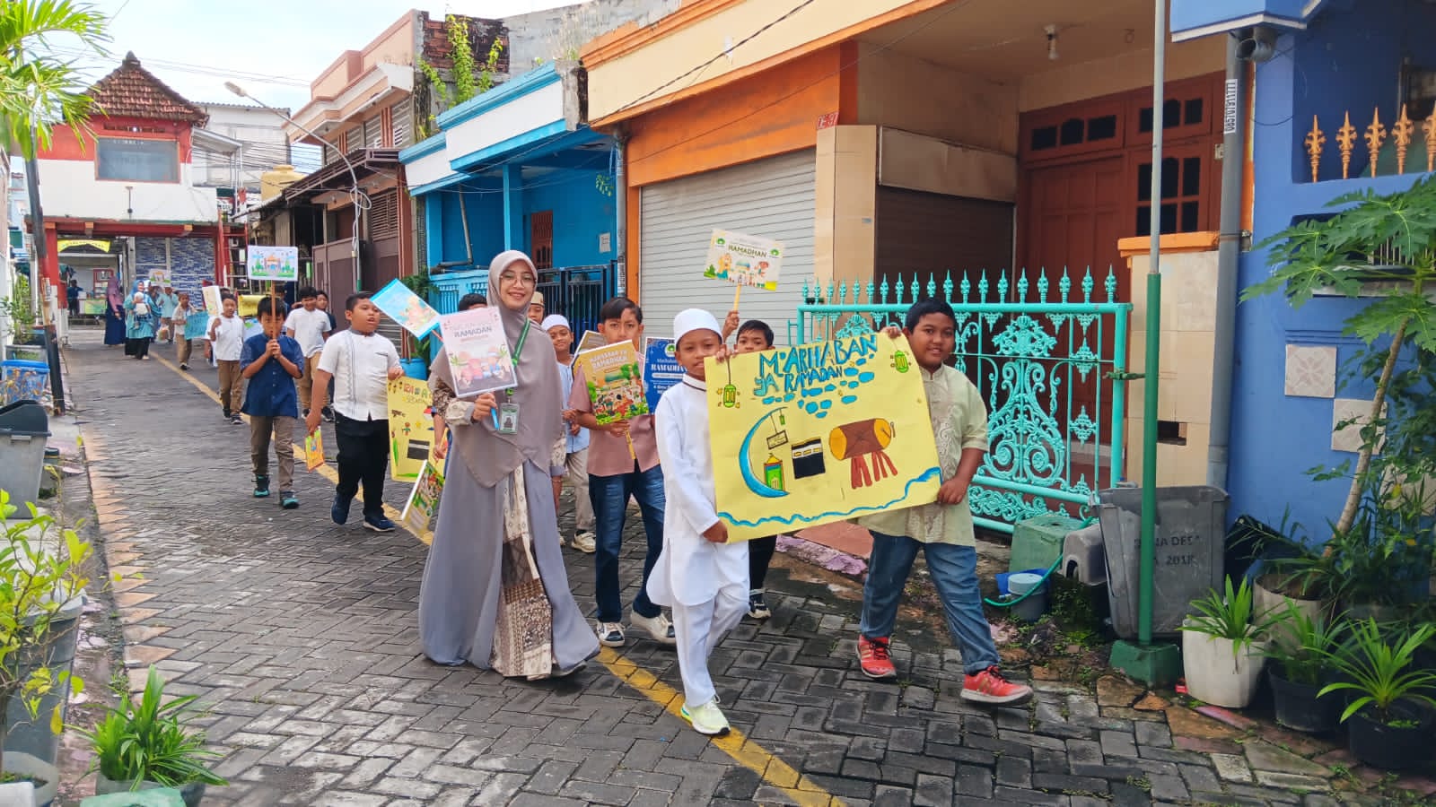 Busana muslim warna-warni dan poster “Marhaban ya Ramadan” memenuhi kawasan Kedanyang, Kebomas, Gresik. Pawai Ramadan SD Almadany menjadi ruang edukasi sekaligus siar menyambut bulan suci.